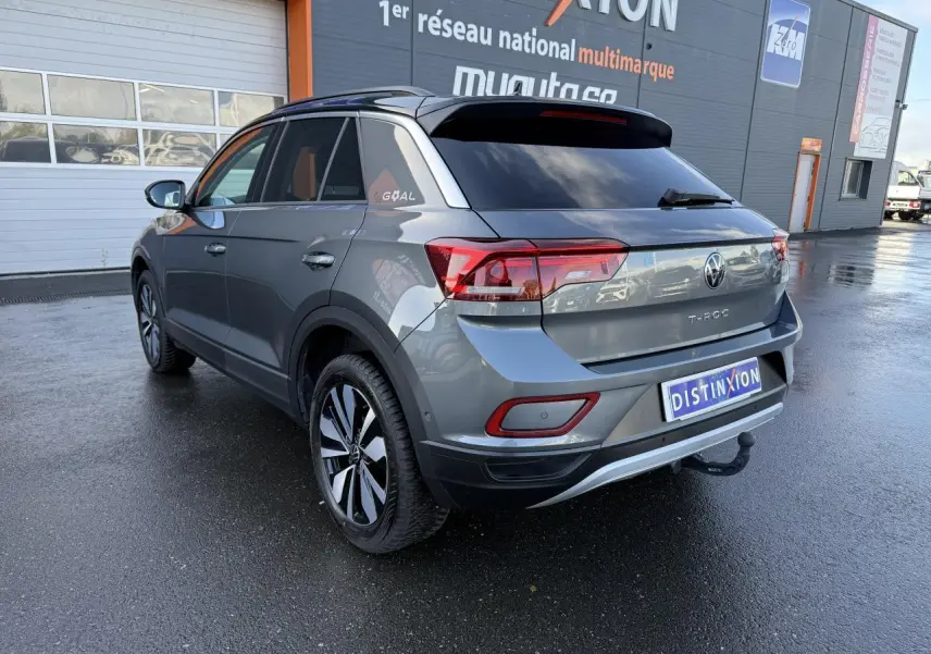 Volkswagen T-Roc gris Indium métallisé vu en 3/4 arrière droit avec attelage amovible et toit noir.