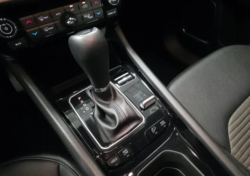 Gros plan sur la console centrale de la Jeep Compass 2024 noire, montrant levier de vitesse automatique et commandes 4WD.