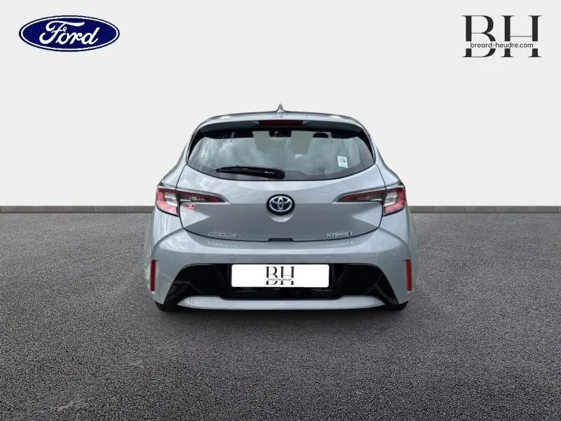 Vue arrière d'une Toyota Corolla 122h Dynamic Business 2020 en gris Manhattan métallisé avec feux arrière LED et logo Toyota central.
