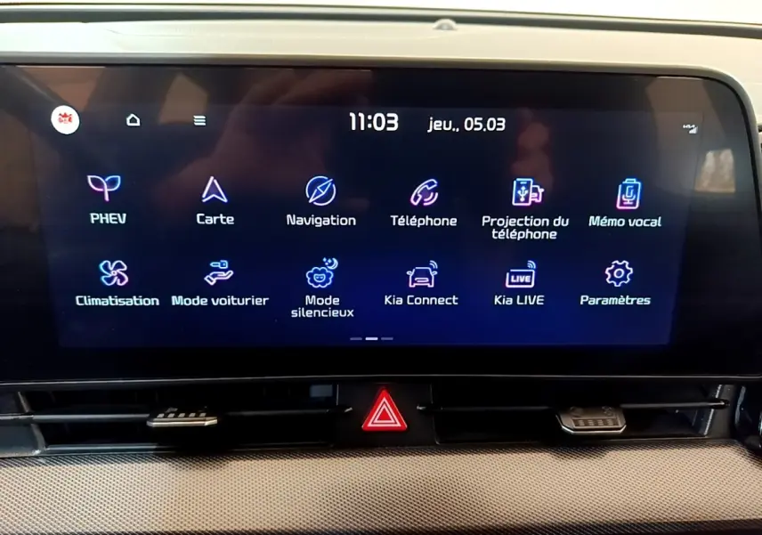 Écran tactile central du tableau de bord du Kia Sportage hybride rechargeable, affichant les options de navigation et connectivité.