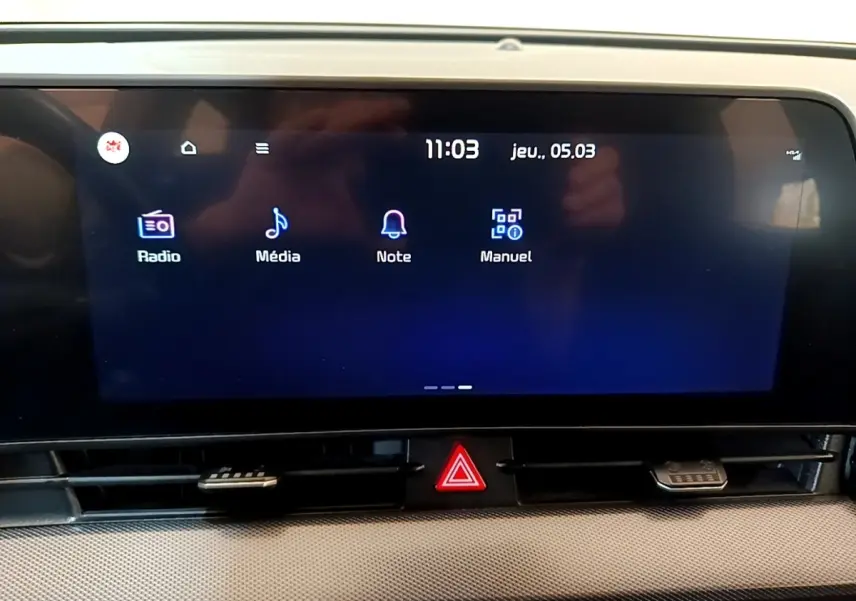 Écran tactile central du tableau de bord du Kia Sportage blanc, affichant les options Radio, Média, Note et Manuel.