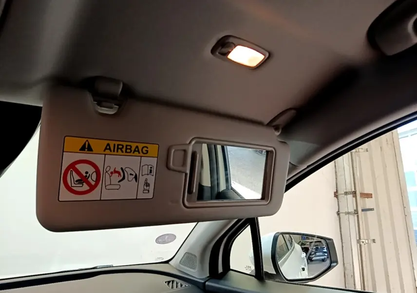 Vue intérieure du pare-soleil côté conducteur avec miroir et airbag dans un KIA Sportage blanc de 2022.