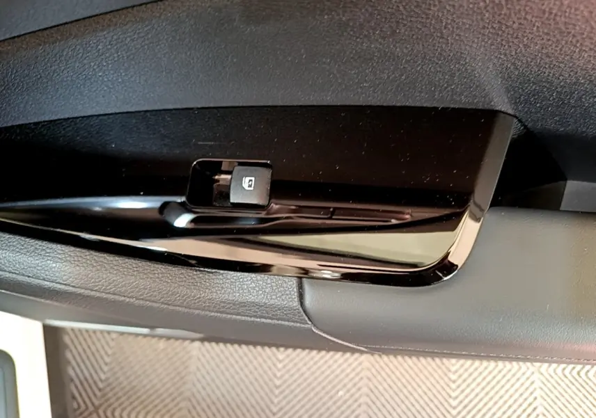 Gros plan sur le bouton de verrouillage des vitres côté conducteur du KIA Sportage blanc 2022.