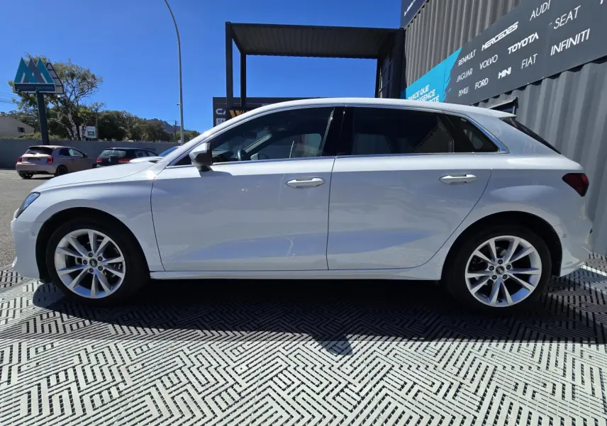 Audi A3 Sportback blanc Arkona vue de profil côté gauche, avec jantes alliage 5 branches parallèles.