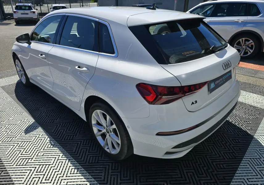 Audi A3 Sportback blanc Arkona vue 3/4 arrière droit, avec feux arrière LED et jantes alliage 5 branches.