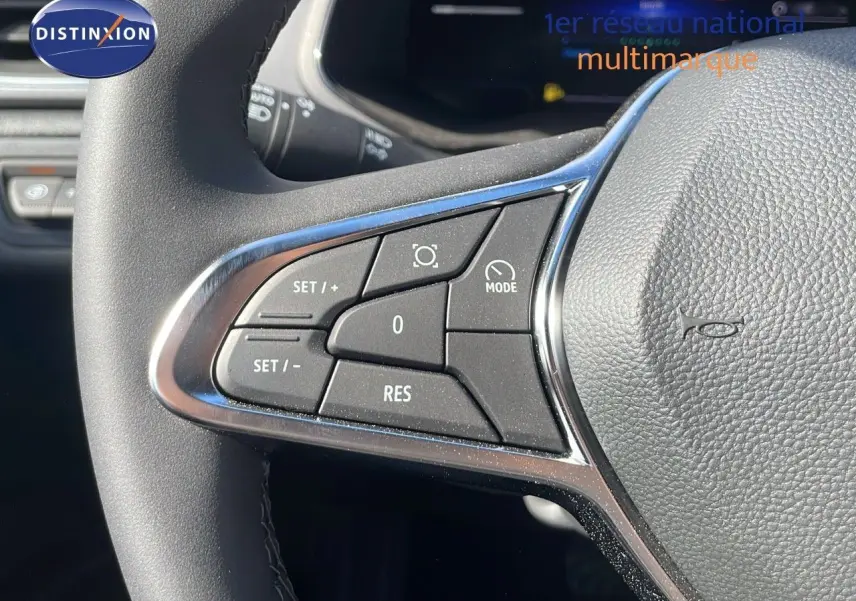 Gros plan sur les commandes gauche du volant du Renault Captur 2025, finition noire avec insert chromé.