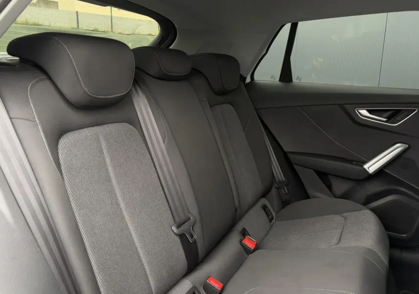 Vue latérale droite des sièges arrière en tissu gris foncé de l'Audi Q2 30 TFSI 110 S-Line 2024.