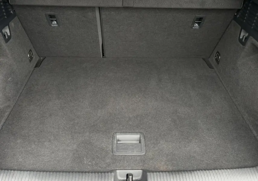 Vue intérieure du coffre spacieux et tapissé de moquette grise de l'Audi Q2 30 TFSI 110 S-Line 2024.