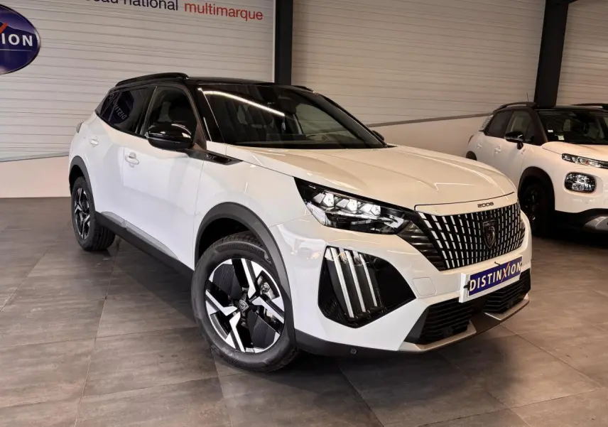 Peugeot 2008 blanc en 3/4 avant droit avec toit noir et calandre distinctive GT dans un showroom.