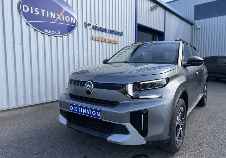 Vue 3/4 avant droite d'une Citroën C3 Aircross électrique gris Mercury avec toit noir et signature lumineuse LED.