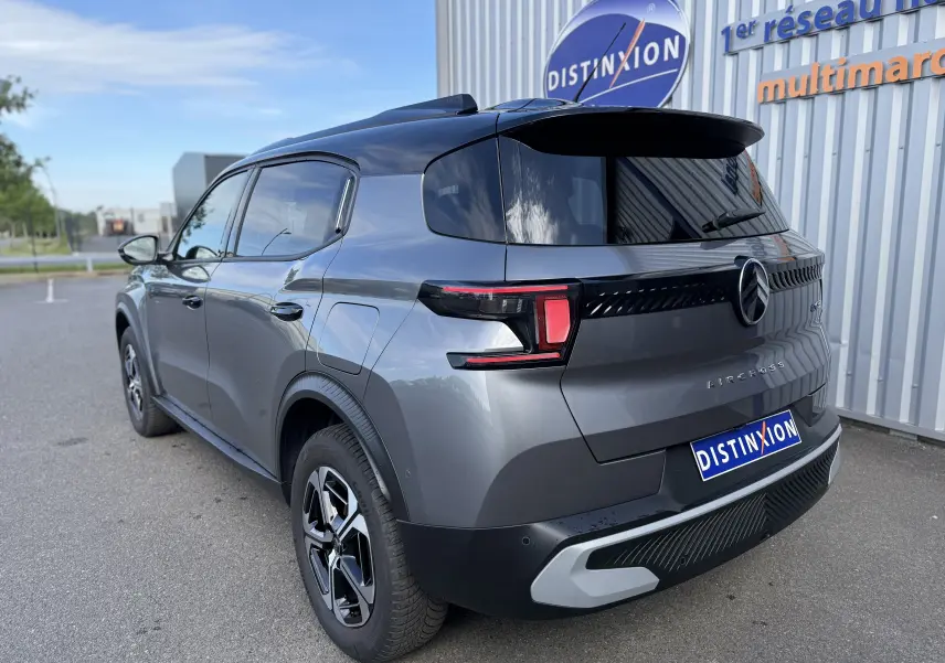 Vue 3/4 arrière droite d'un Citroën C3 Aircross électrique gris Mercury avec toit noir et feux arrière LED distinctifs.