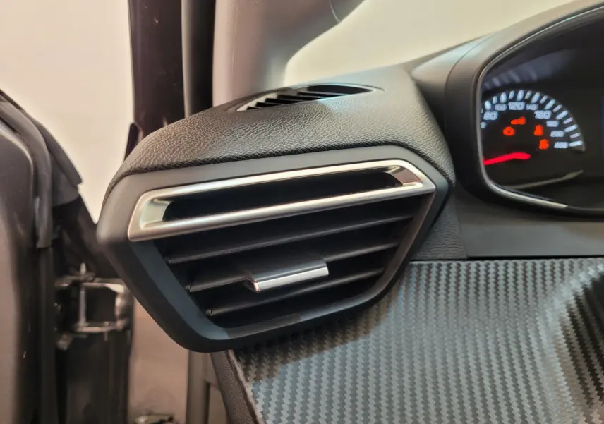 Détail de la sortie d'air côté gauche avec tableau de bord effet carbone du Peugeot 208 gris foncé 2023.