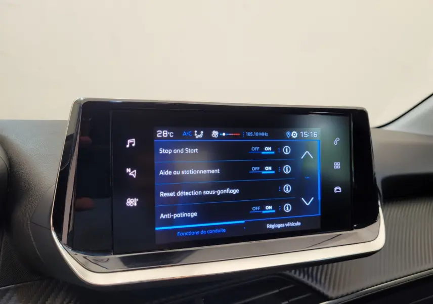 Écran tactile central de la Peugeot 208 gris foncé, affichant les réglages d'aide à la conduite en gros plan.