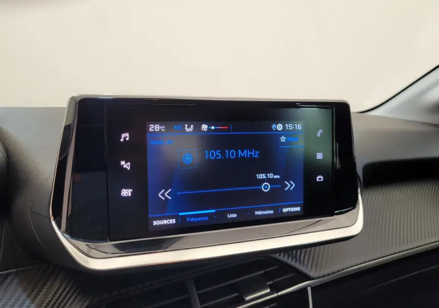Écran tactile central 7 pouces de la Peugeot 208 gris foncé, affichant la radio FM à 105,10 MHz.