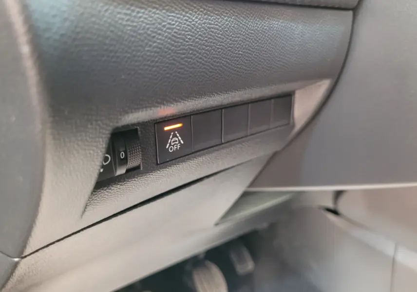 Gros plan sur le tableau de bord côté conducteur de la Peugeot 208 gris foncé, bouton d'alerte de franchissement de ligne activé.