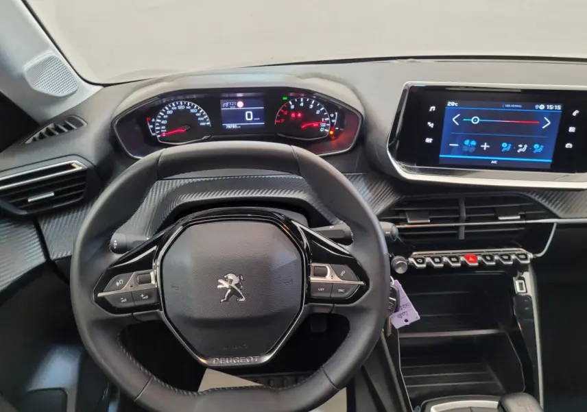 Vue intérieure centrée sur le volant cuir et tableau de bord numérique de la Peugeot 208 2023, finition Active Pack.