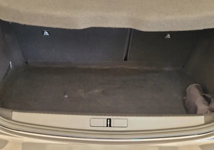Coffre ouvert d'une Peugeot 208 gris foncé 2023, vue arrière montrant l'espace de chargement vide.