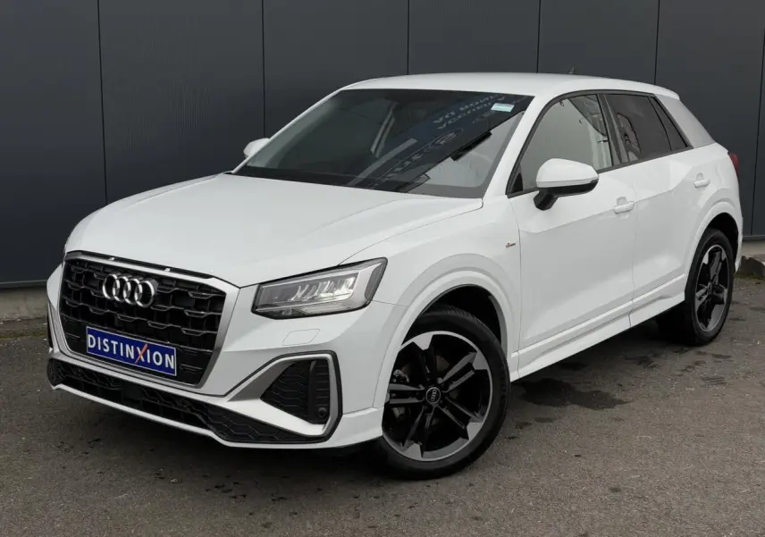 Audi Q2 30 TFSI S-Line blanc Glacier en 3/4 avant droit avec jantes alliage noir poli et vitres surteintées.