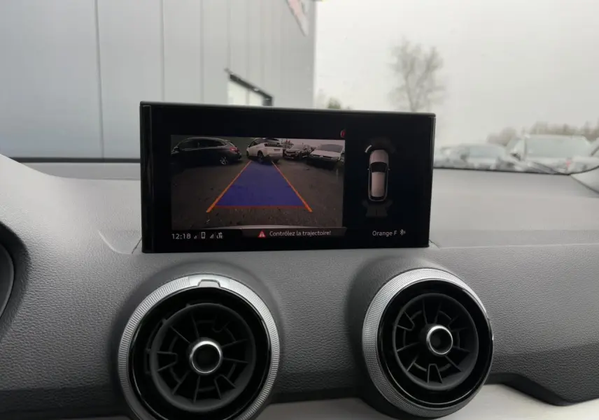 Vue intérieure du tableau de bord de l'Audi Q2 30 TFSI S-Line 2024, écran affichant la caméra de recul.