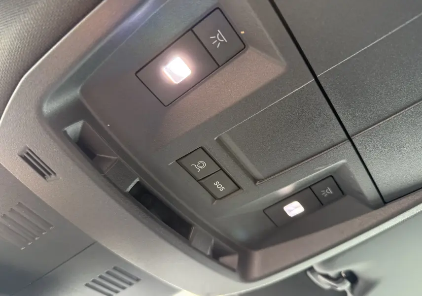 Vue en gros plan du plafonnier intérieur du Peugeot 3008 Hybrid 2026 avec boutons d’éclairage et alarme SOS.