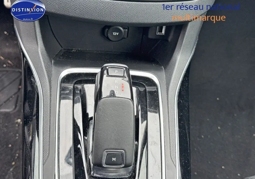 Le levier de vitesses automatique noir de la Peugeot 308 gris Artense vu de dessus, avec prise 12V et port USB à l'arrière.