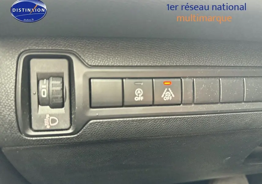 Gros plan sur les commandes de réglage des phares et d'assistance à la conduite dans l'habitacle d'une Peugeot 308 gris Artense.