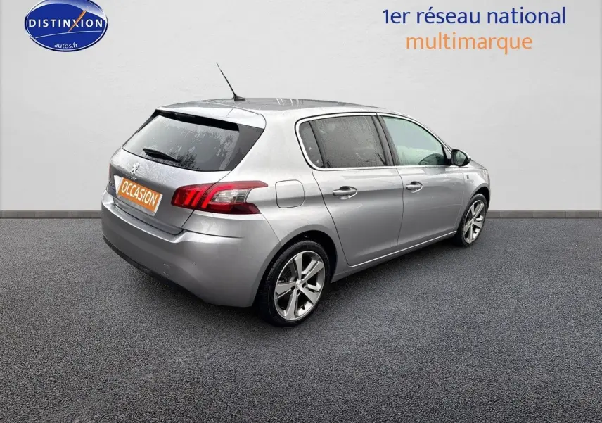 Peugeot 308 gris Artense vue 3/4 arrière droit, compacte cinq portes avec jantes alliage et feux LED distinctifs.