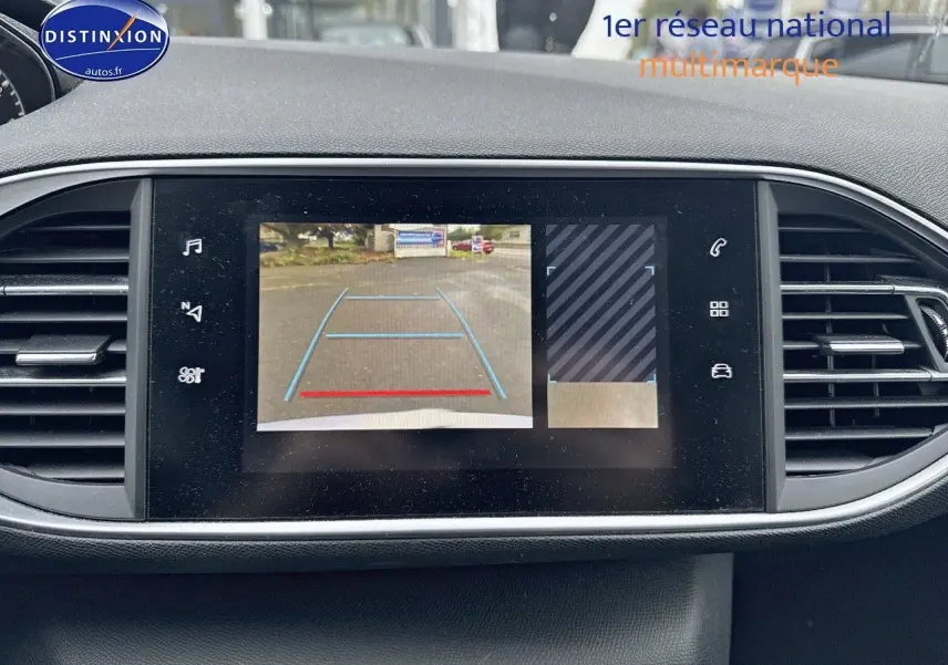 Écran central de la Peugeot 308 gris Artense de 2019 montrant la caméra de recul avec lignes de guidage bleues et rouges.