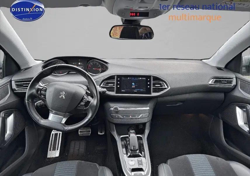 Intérieur avant de la Peugeot 308 gris Artense 2019, vue du tableau de bord et volant côté gauche avec écran tactile central.