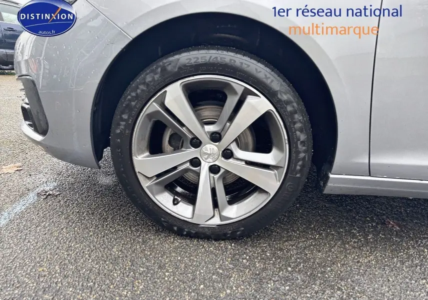 Gros plan sur la roue avant gauche d'une Peugeot 308 gris Artense avec jante alliage 17 pouces.