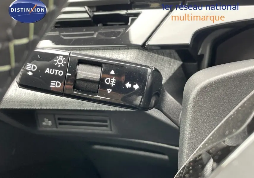 Gros plan sur la commande des phares et clignotants du Peugeot 5008 Hybrid gris titane, intérieur noir.