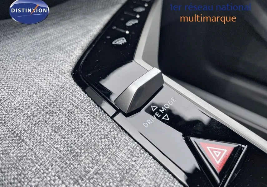 Gros plan sur la commande Drive Mode et bouton de signalisation d'urgence du Peugeot 5008 hybride gris titane intérieur tissu gris.