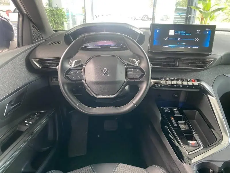 Vue intérieure du poste de conduite du Peugeot 3008 2023, volant cuir multifonction et écran tactile 10 pouces visible.