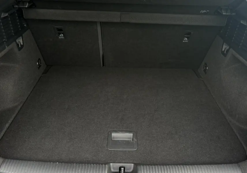 Vue intérieure du coffre spacieux et vide de l'Audi Q2 30 TFSI S-Line, avec revêtement noir uniforme.