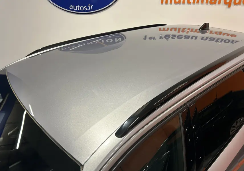 Vue plongeante sur le toit gris Artense du Peugeot 5008 III Hybrid 145 e-DCS6 Allure avec antenne requin et barres de toit noires.