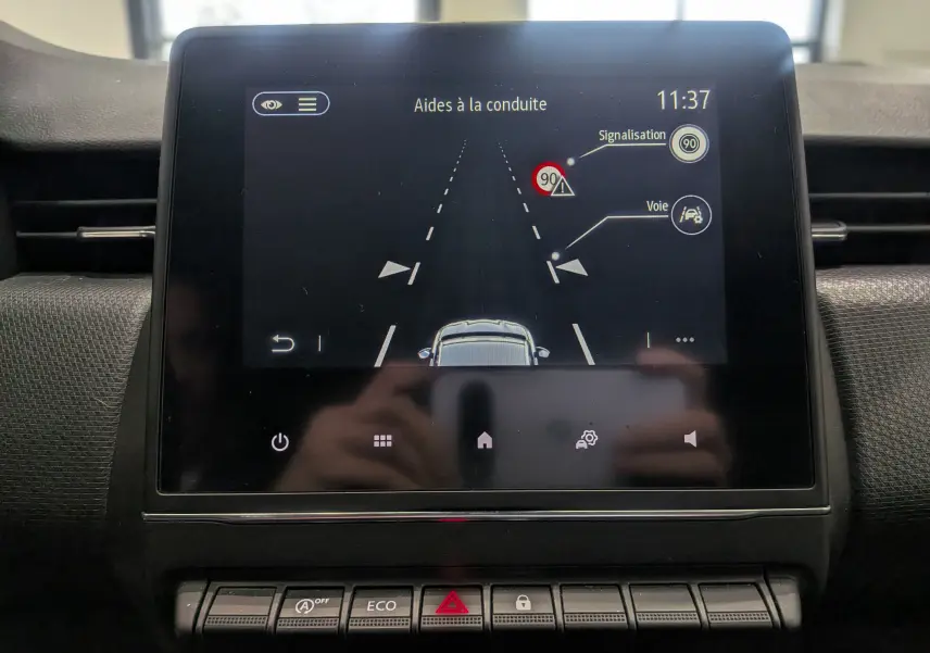 Écran central de la Renault Clio V TCe 90 Auto-école montrant les aides à la conduite avec affichage de la signalisation et voie.