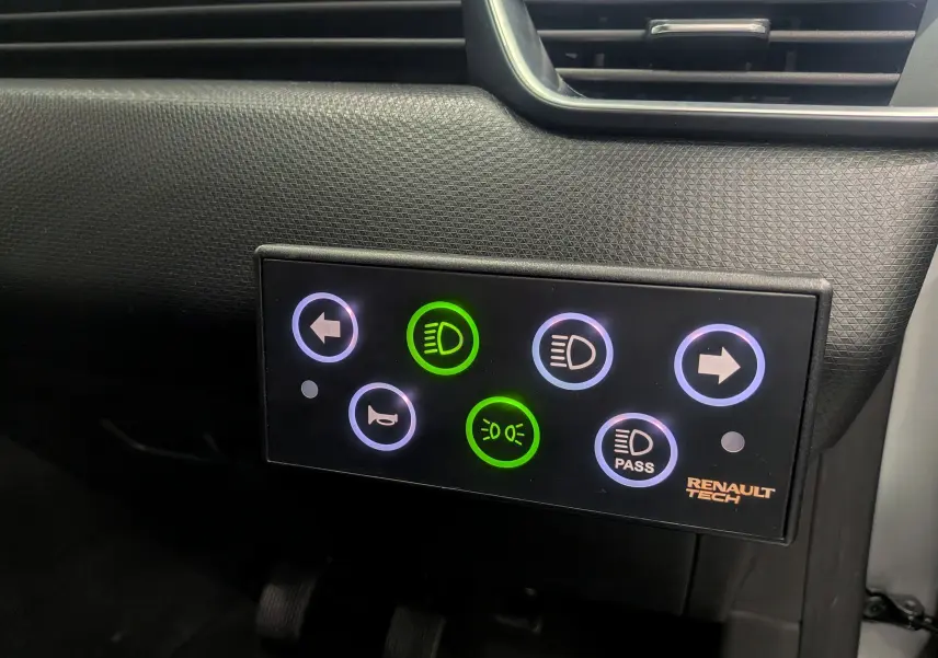 Vue rapprochée du tableau de bord de la Renault Clio V gris platine, avec panneau lumineux de commandes éclairées.