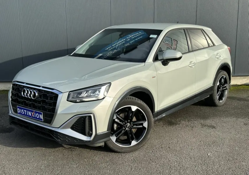 Audi Q2 30 TFSI S-Line 2024 argent rosé, vue 3/4 avant droit, jantes alliage noir poli et vitres surteintées.