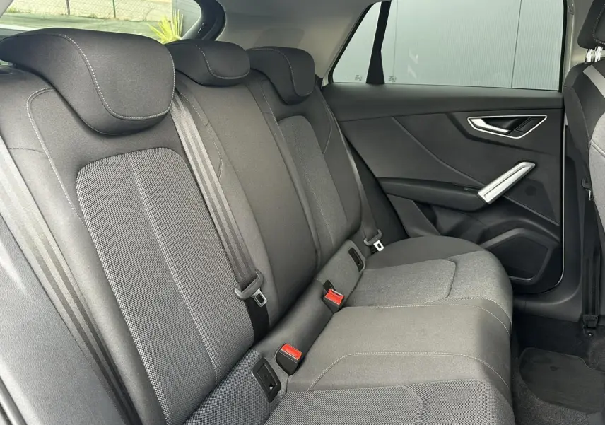 Vue intérieure côté droit des sièges arrière en tissu gris de l'Audi Q2 30 TFSI 110 S-Line 2024.