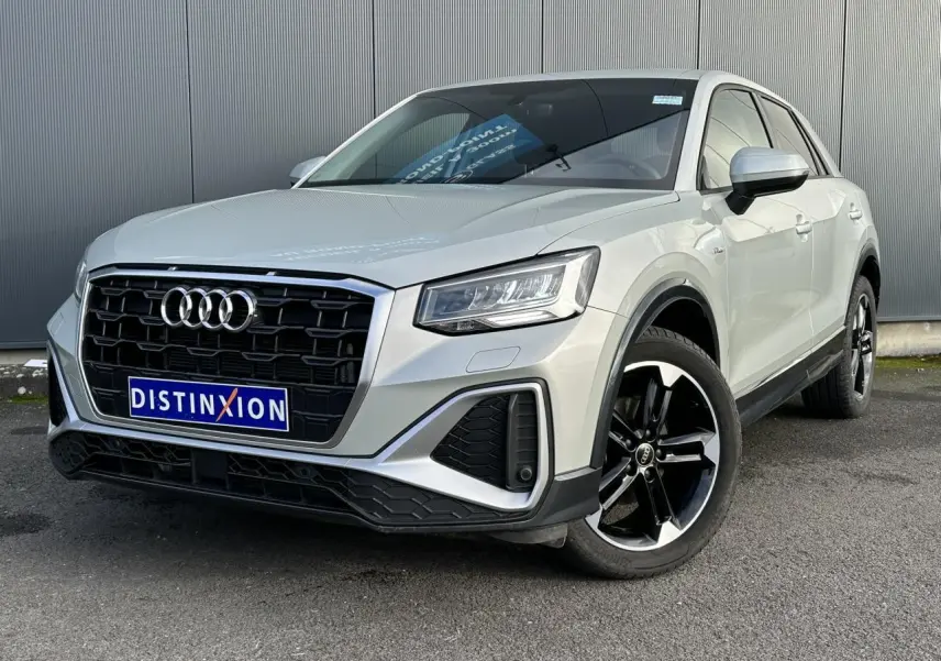 Audi Q2 30 TFSI S-Line argent rosé en 3/4 avant droit avec jantes noires et calandre noire distinctive.