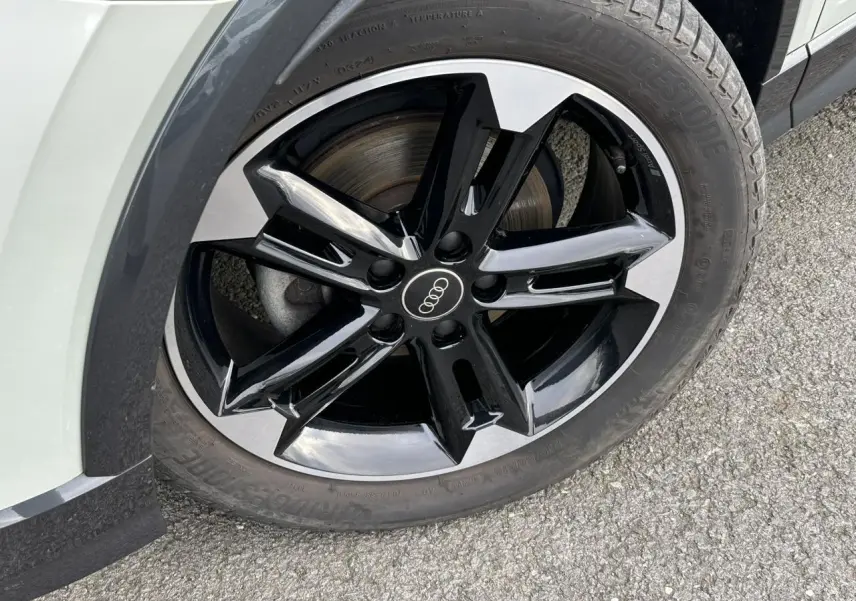 Gros plan sur la jante alliage noir et poli 7x18 à 5 branches doubles de l'Audi Q2 argent rosé, côté avant droit.