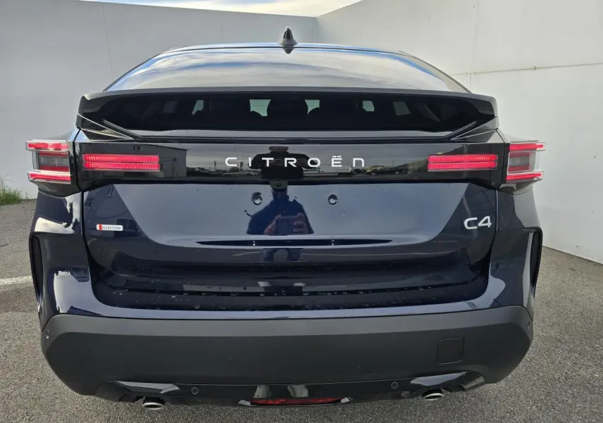 Vue arrière d'une Citroën C4 III hybride bleu eclipse avec toit noir et feux arrière LED distinctifs.