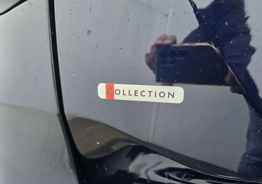 Gros plan sur l'écusson "COLLECTION" sur la portière bleu eclipse d'une Citroën C4 III hybride 2025.
