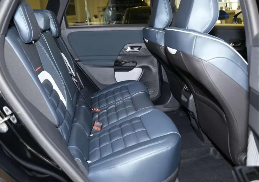Vue intérieure côté gauche montrant la banquette arrière en cuir bleu matelassé du Citroën C5 Aircross New Hybrid 2026.