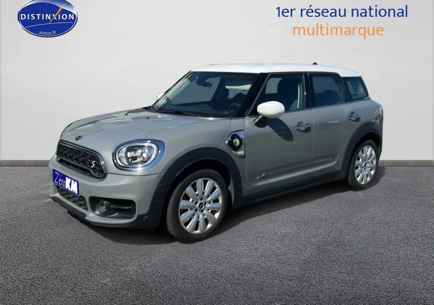Vue 3/4 avant droite d'une MINI Countryman Cooper SE hybride rechargeable en Moonwalk Grey avec toit blanc et jantes alu design Pin Spoke.