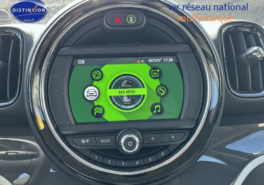 Écran multifonction circulaire du tableau de bord MINI Countryman avec interface verte et commandes intégrées.