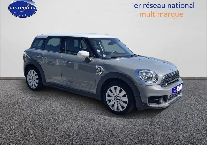 Vue 3/4 avant droit d'une MINI Countryman hybride rechargeable Moonwalk Grey avec toit et rétroviseurs blancs.