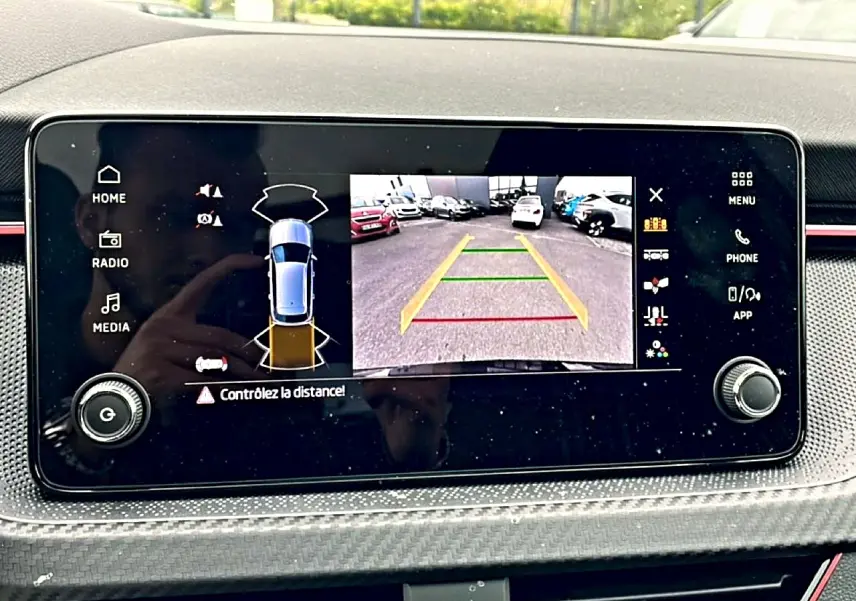 Écran tactile intérieur du Skoda Kamiq noir montrant la caméra de recul avec guidage de trajectoire coloré.