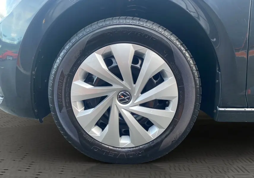 Gros plan sur la roue avant gauche noire intense d'une Volkswagen Polo 2019 avec jante argentée au design moderne.