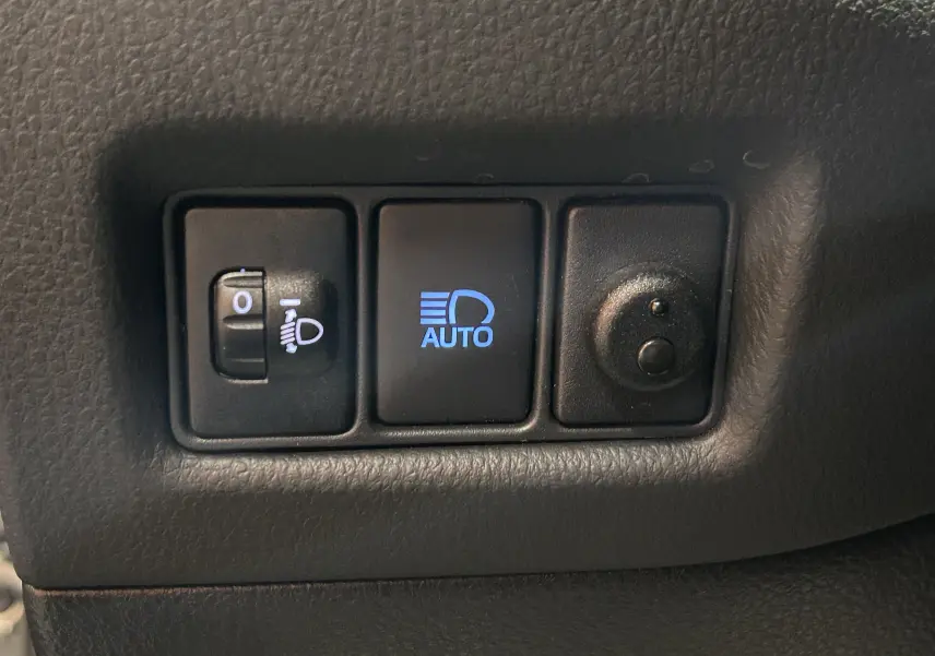 Panneau de commandes des phares avec réglage manuel et mode automatique, intérieur noir du Toyota C-HR Hybride 2021.